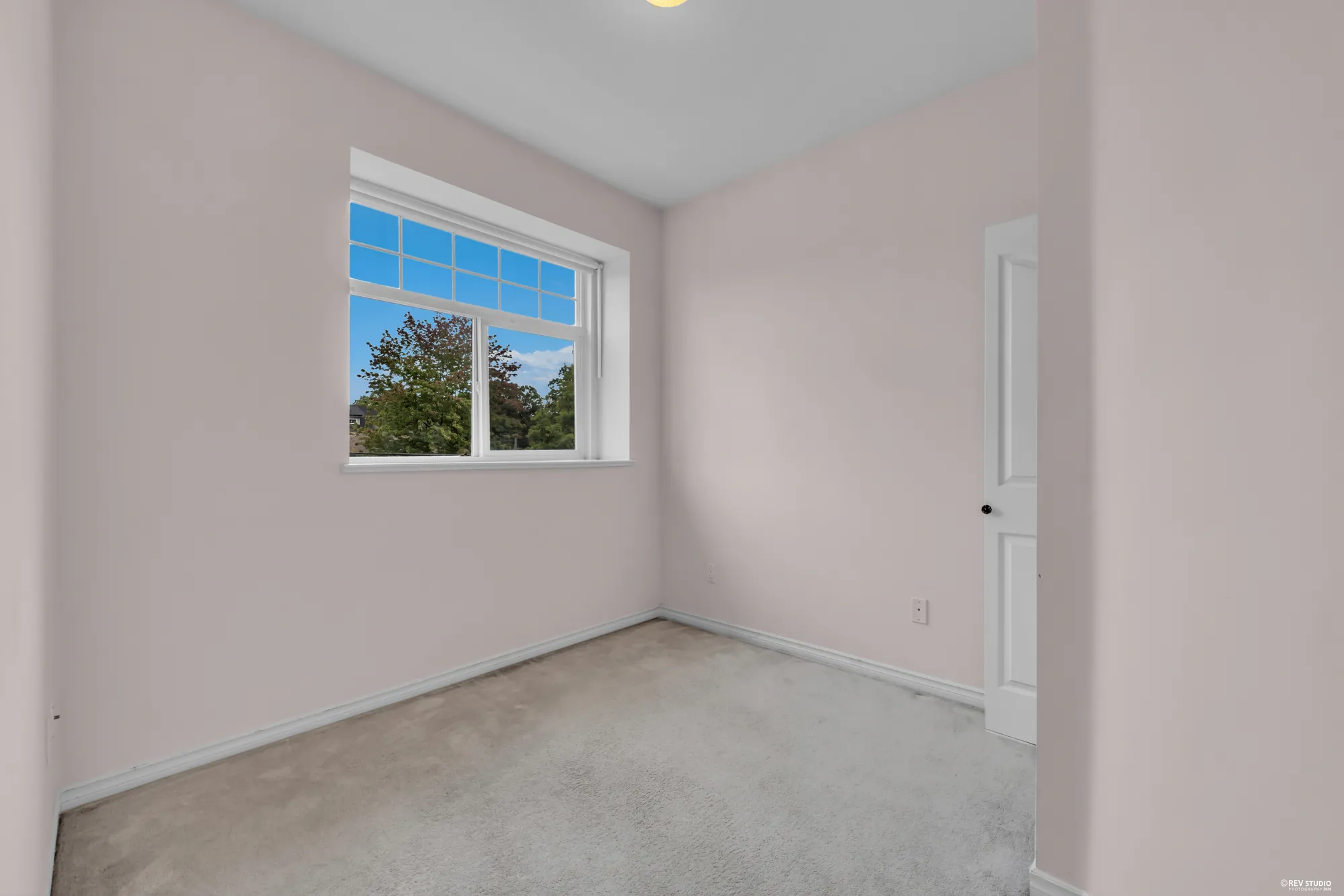 An upstairs bedroom with a window to the trees
