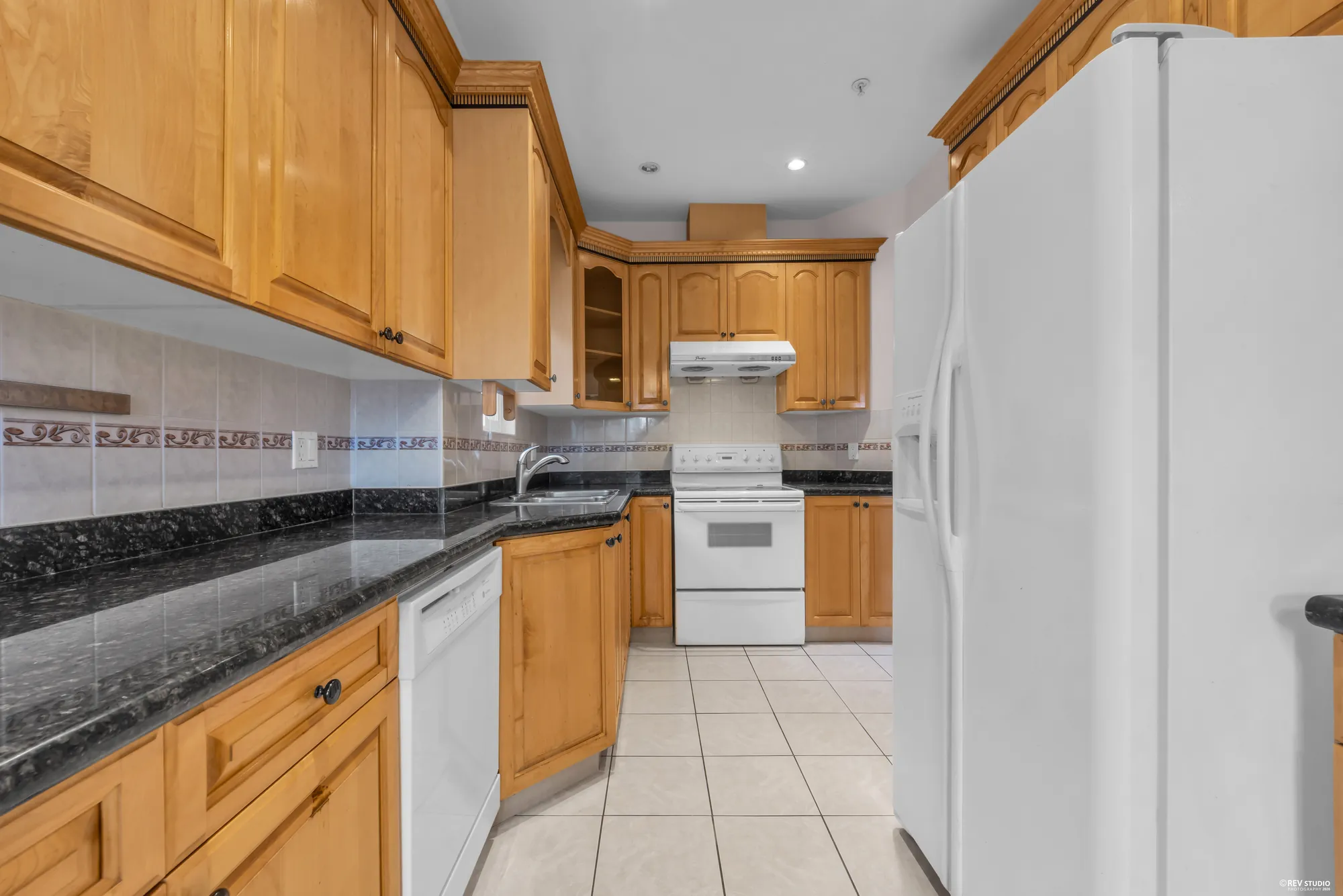 The upper kitchen from the other end, with the refrigerator and the counter run