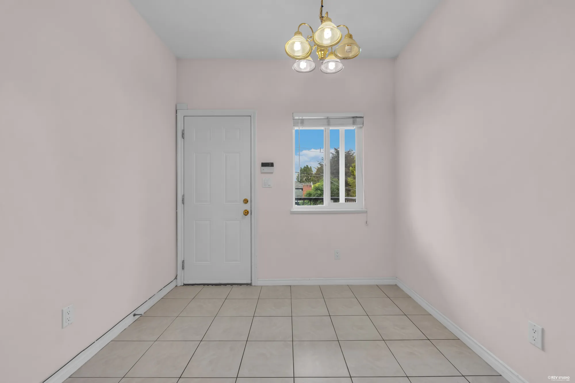 The main-floor entrance with a door to the outside and a window beside it