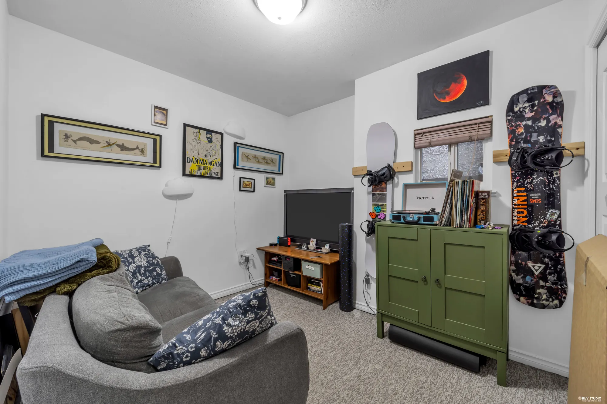 A main-floor sitting room, occupied, with a sofa and a television